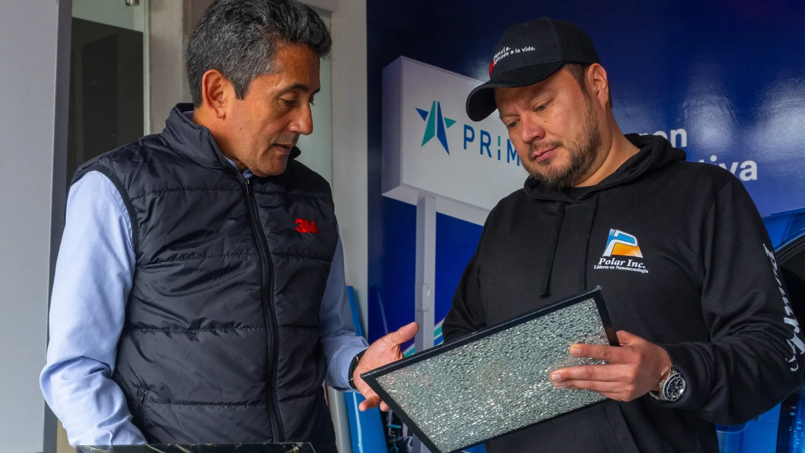Asesor de 3M y Polar Inc. revisan muestras de vidrio roto con película de seguridad en las instalaciones de 3M